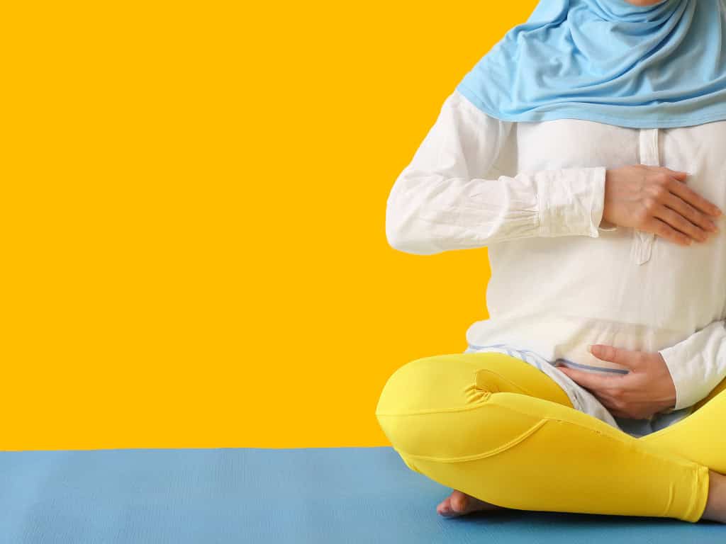 Person meditating in yellow and blue outfit