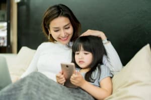 Woman and child using smartphone together.