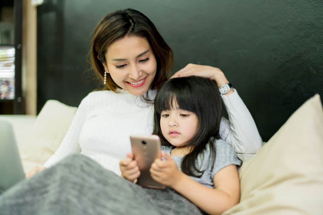Woman and child using smartphone together.