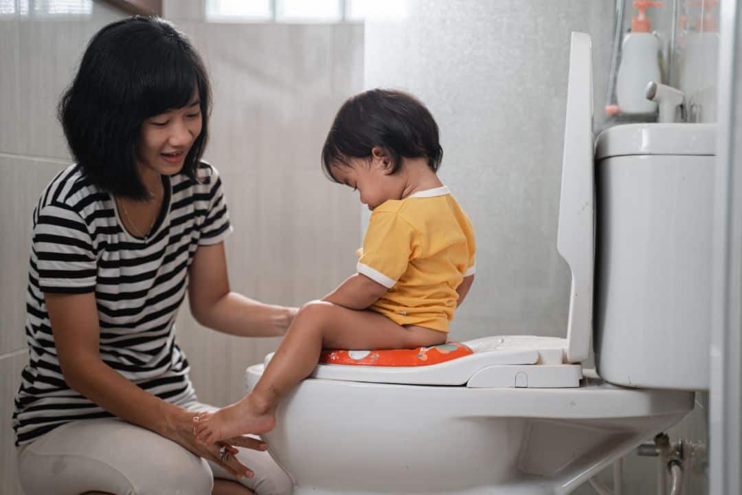 Mother assists child with potty training